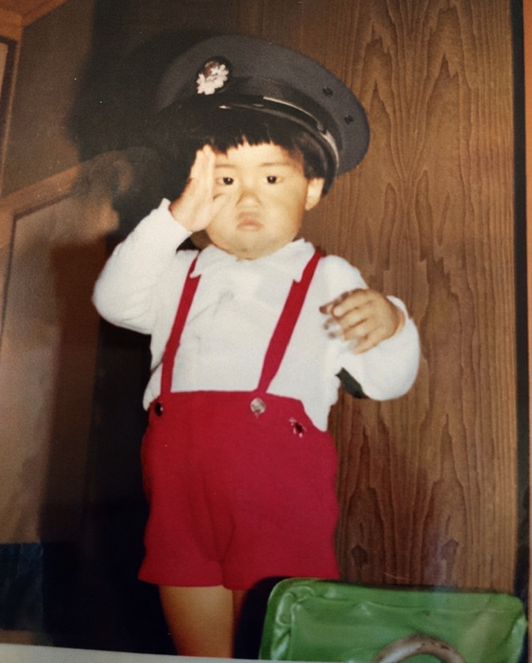国鉄の車掌の制帽をかぶって敬礼する4歳くらいの妹。