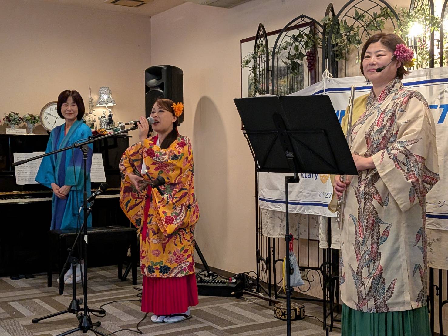 宇部東ロータリークラブ家族会での演奏中に話をする島袋
